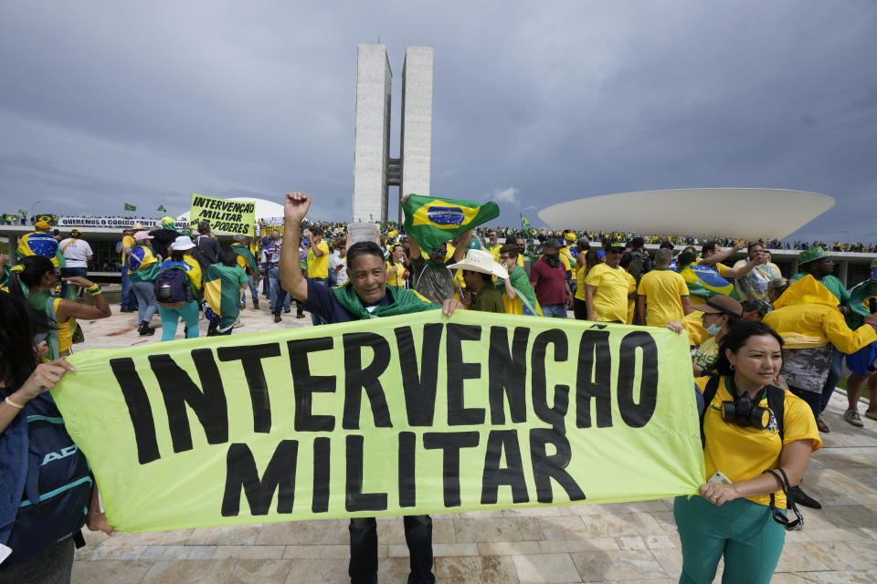 FILE - Supporters of Brazil's former President Jair Bolsonaro hold a banner that with a message that reads in Portuguese: "Military Intervention," as they storm the the National Congress building in Brasilia, Brazil, Jan. 8, 2023. Mimicking the Jan. 6, 2021, insurrection by defenders of outgoing U.S. President Donald Trump at the Capitol in Washington, thousands of Bolsonaro’s supporters stormed the presidential palace, Congress and the Supreme Court buildings, last year, in one of the biggest challenges to Latin America’s most populous democracy. (AP Photo/Eraldo Peres, File)
