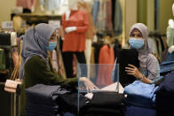 Shoppers wearing a face mask to help curb the spread of the coronavirus shopping at mall in Putrajaya, Malaysia, Monday, Oct. 5, 2020. Prime Minister Muhyiddin Yassin says he will self-quarantine after a Cabinet minister he was in contact with tested positive for the coronavirus. (AP Photo/Vincent Thian)