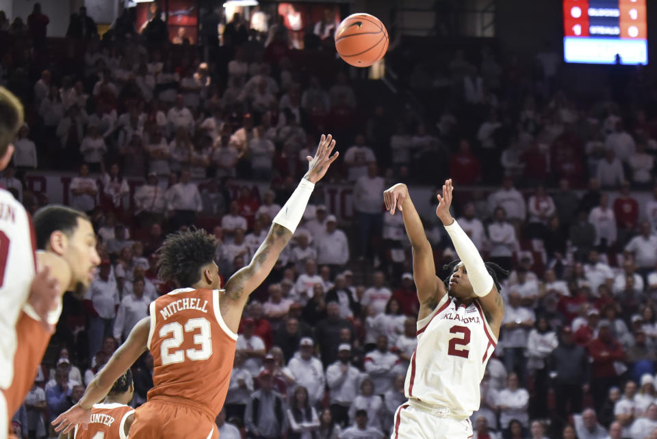 Oklahoma guard Javian McCollum (2) shoots over Texas forward Dillon Mitchell (23) during the first half of an NCAA college basketball game Tuesday, Jan. 23, 2024, in Norman, Okla. (AP Photo/Kyle Phillips)