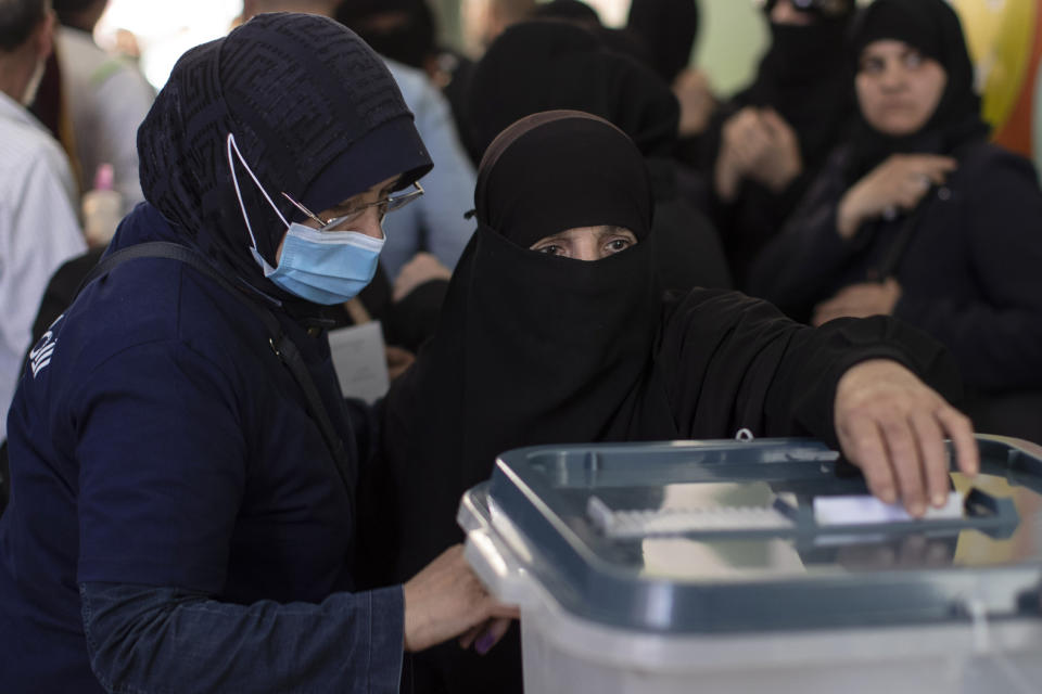 A Syrian woman votes during the Presidential elections, at a polling station in the town of Douma, near the Syrian capital Damascus, Syria, Wednesday, May 26, 2021. Syrians headed to polling stations early Wednesday to vote in the second presidential elections since the deadly conflict began in the Arab country. (AP Photo/Hassan Ammar)