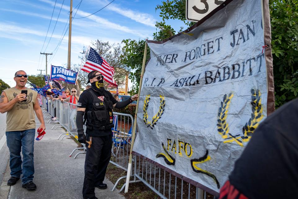 On the anniversary of the Jan. 6, 2021, U.S.  Capitol attack, men dressed in Proud Boys attire put up a sign for Ashli Babbitt as they attend a Trump rally in West Palm Beach.