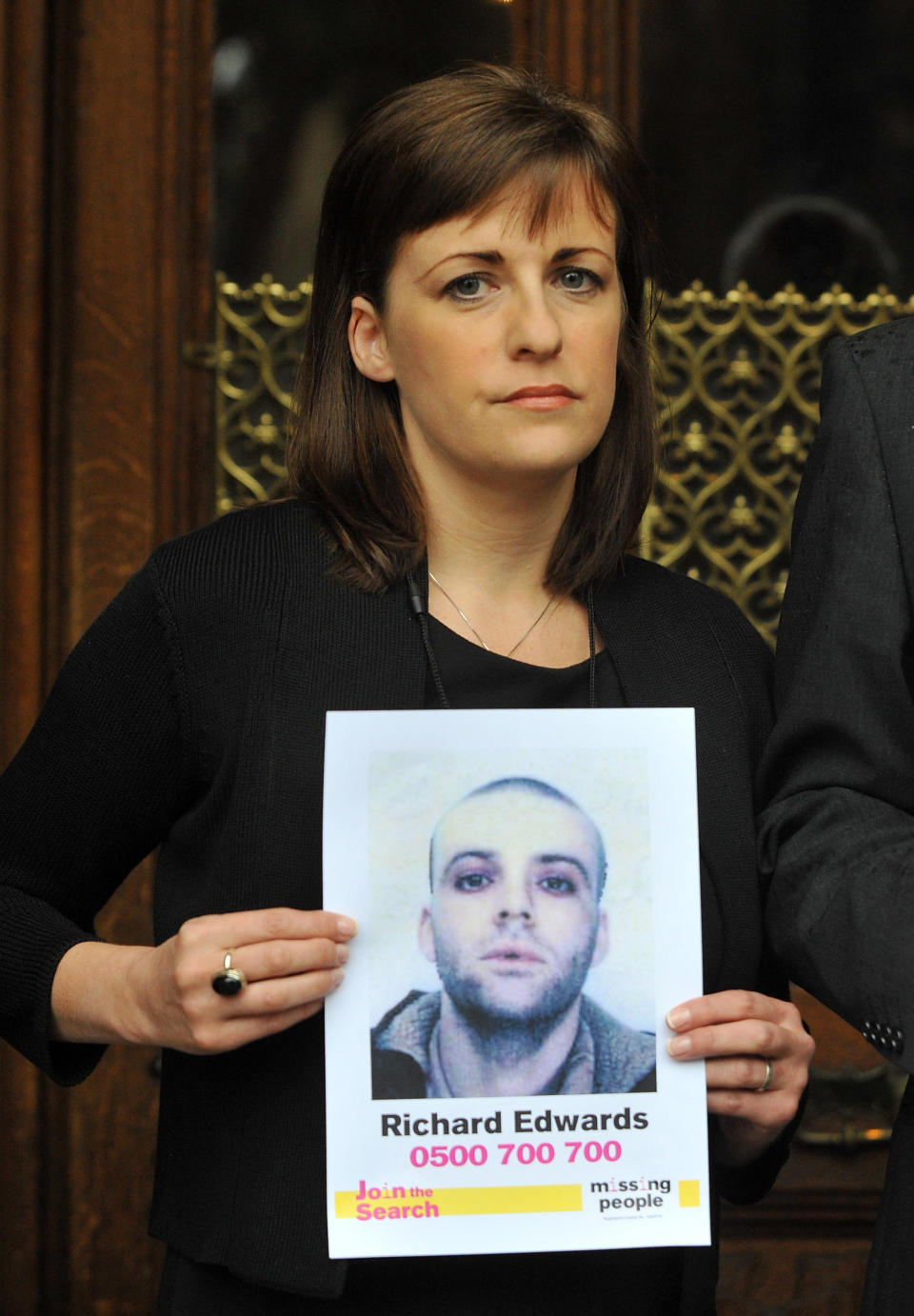 Rachel Elias, sister of missing Manic Street Preachers guitarist Richey Edwards, holds up posters of her missing loved one outside the Houses of Parliament, London, ahead of her giving evidence at the UK's first Parliamentary Inquiry into the rights of families of missing people.   (Photo by Clive Gee/PA Images via Getty Images)