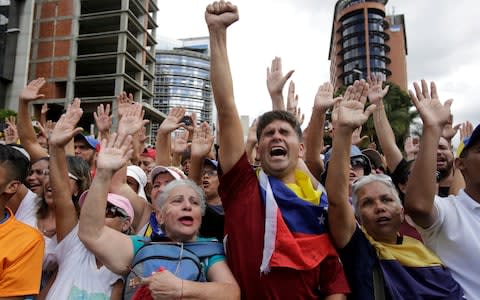 Anti-government protesters cheer after Juan Guaido, head of Venezuela's opposition-run congress, declared himself interim president - Credit: Boris Vergara&nbsp;/AP