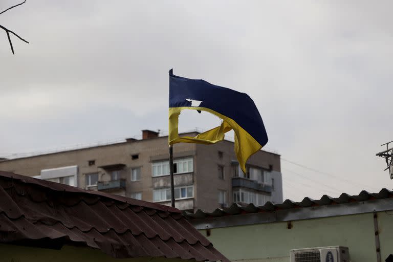 Una bandera ucraniana desgarrada en fragmentos tras los bombardeos rusos ondea en Mykolaiv, una ciudad clave en el camino a Odessa, el puerto m&#xe1;s grande de Ucrania el 27 de marzo de 2022. - Despu&#xe9;s de unas terribles semanas en las que el ej&#xe9;rcito ruso ha intentado en vano volar esta estrat&#xe9;gica ciudad, la amenaza en los &#xfa;ltimos d&#xed;as parece haber disminuido un poco. Durante el fin de semana, las sirenas antia&#xe9;reas ya no molestaban a los habitantes de Mykolaiv, que se aventuraban cada vez m&#xe1;s a salir a la calle. La mayor&#xed;a apenas se apresura cuando los escucha. (Foto de Oleksandr GIMANOV / AFP)