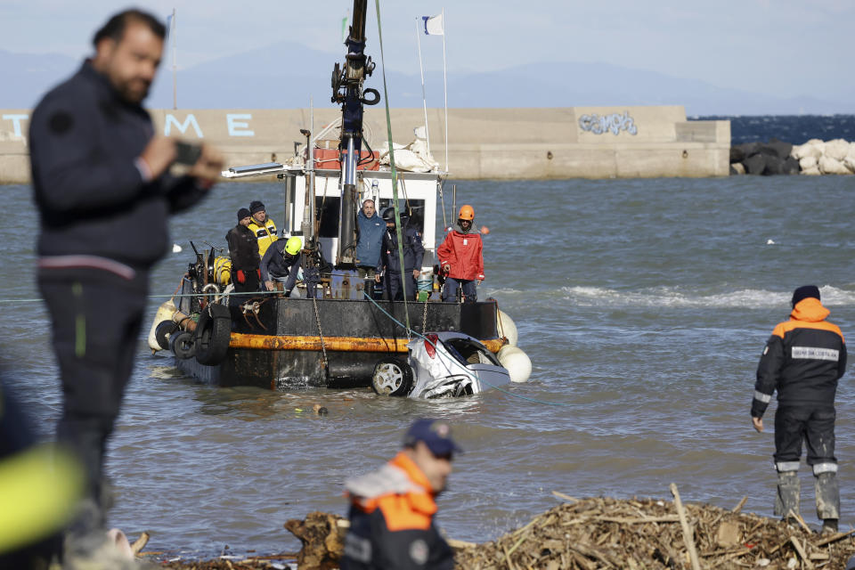 Rescuers remove damaged car from a sea after heavy rainfall triggered landslides that collapsed buildings and left as many as 12 people missing, in Casamicciola, on the southern Italian island of Ischia, Sunday, Nov. 27, 2022. Firefighters are working on rescue efforts as reinforcements are being sent from nearby Naples, but are encountering difficulties in reaching the island either by motorboat or helicopter due to the weather. (AP Photo/Salvatore Laporta)