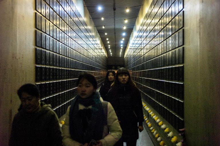 Visitors walk through a corridor displaying the names of Chinese victims at Unit 731, with Japan never having officially acknowledged the atrocities that took place there