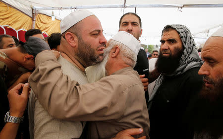 The father of Mohammad Jawawdah is hugged at his son's funeral in Amman, Jordan July 25, 2017. REUTERS/Muhammad Hamed