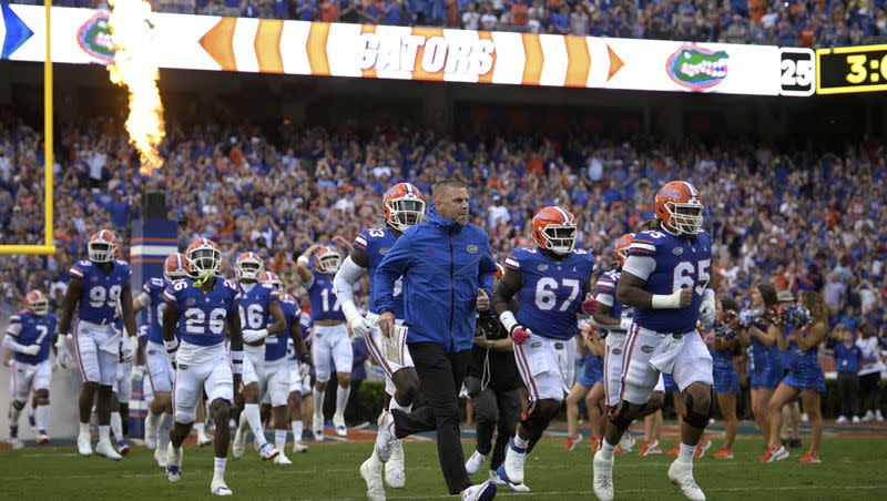 Florida coach Billy Napier, center, leads his team onto the field before game against Utah, Saturday, Sept. 3, 2022, in Gainesville, Fla. The two teams will meet again Thursday in Salt Lake City in the season opener for both teams. 