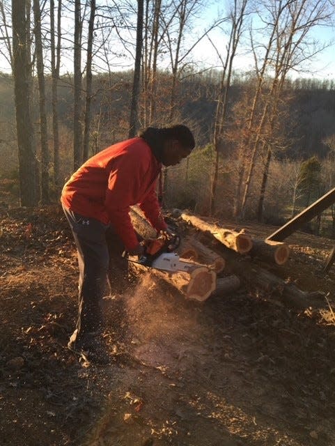 An outdoorsman from a young age, Ty Chandler works with a chainsaw.