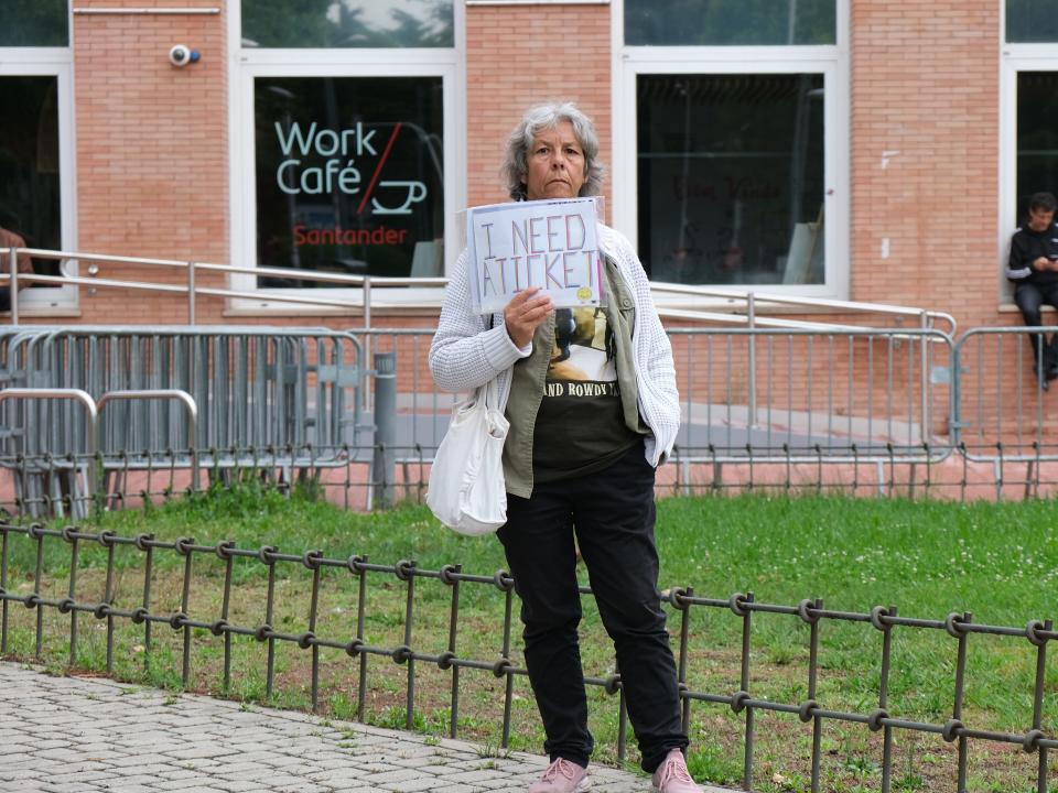 A woman with a sign asks for a ticket before the concert of Bob Dylan, at the Alfonso XIII Botanical Garden of the Complutense University of Madrid, on June 7, 2023, in Madrid, Spain.