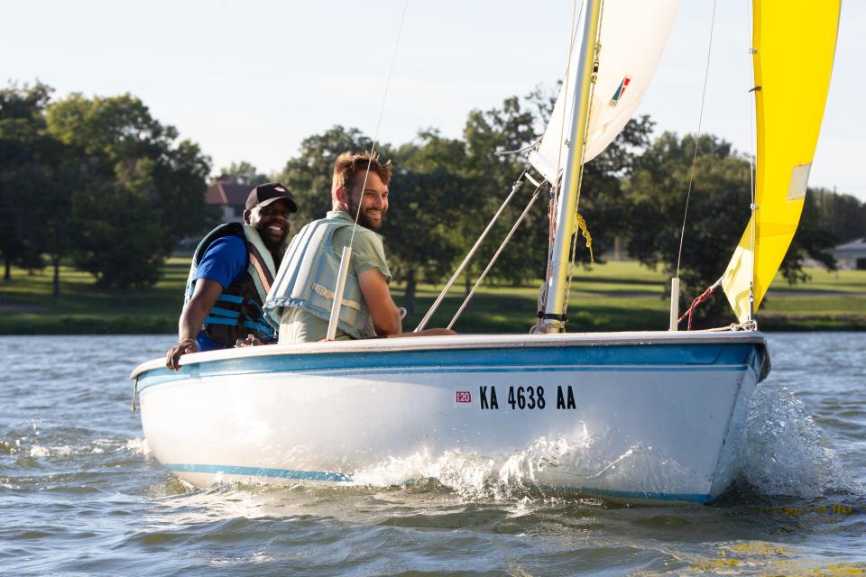 It's all smiles for Eric Stephenson, left, and Joe Glasgow as they adjust their sails and catch the wind on the water at Lake Shawnee. Glasgow has been helping Stephenson, a new member of the Shawnee Yacht Club, with sailing lessons this past summer.