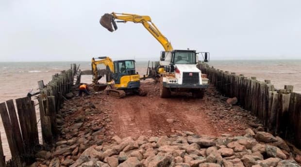 Construction vehicles dismantle Rocky Point wharf and install a rock breakwater. (Aaron MacDonald - image credit)