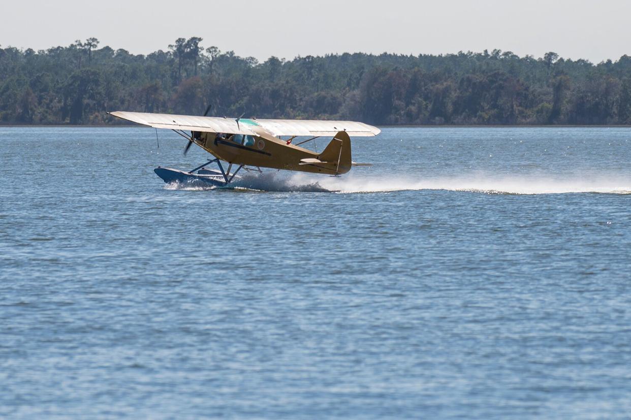 Seaplane taking off on top of a lake.