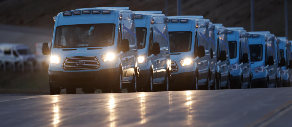 A large procession of emergency vehicles waits for the ambulance carrying the body of retired paramedic Paul Cary late Sunday, May 3, 2020, in Denver. Cary died from coronavirus after volunteering to help combat the pandemic in New York City. (AP Photo/David Zalubowski)
