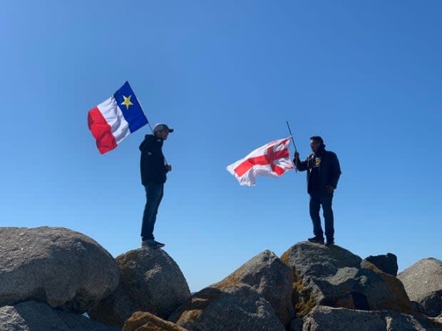 These men are on opposite sides of the dispute over the Mi’kmaw lobster fishery. On the left, a commercial fisherman with an Acadian flag, on the right a supporter of Sipekne’katik’s new rights-based fishery, holding the Mi’kmaw flag