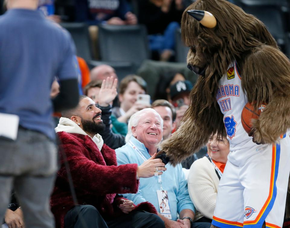Rumble greets Drake during Wednesday's Thunder-Rockets game.