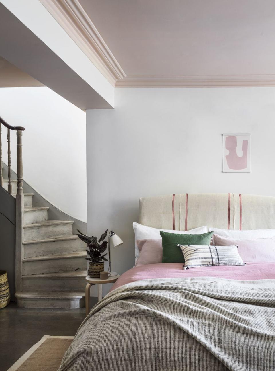 staircase leading into bedroom with pink ceiling