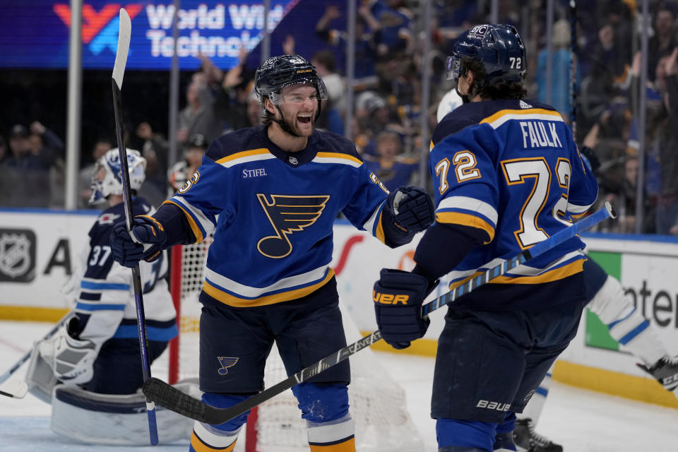 St. Louis Blues' Nathan Walker is congratulated by teammate Justin Faulk (72) after scoring past Winnipeg Jets goaltender Connor Hellebuyck (37) during the second period of an NHL hockey game Sunday, March 19, 2023, in St. Louis. (AP Photo/Jeff Roberson)
