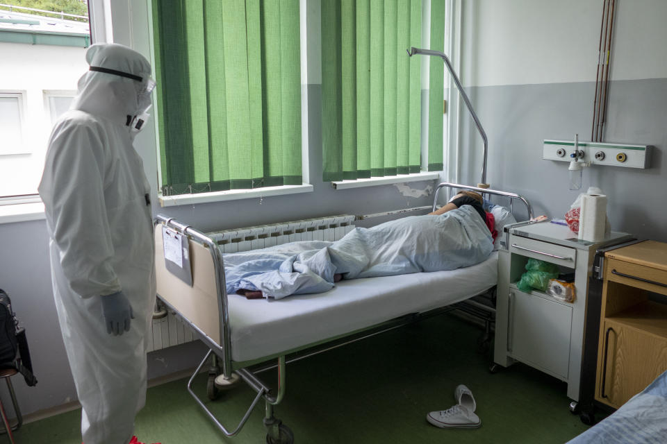 Pulmonologist Besim Prnjavorac, the director of COVID-19 hospital visits a patient at the hospital, in Tesanj, Bosnia, Thursday, Sept. 24, 2020. The coronavirus skeptics and rebels in Bosnia grow louder in step with the rising number of infections in the country. Recently, several families who lost their loved ones to COVID-19 were confronted online, and some even in real life, by scores of random virus believers and deniers sifting through their pain and questioning their relatives’ cause of death. (AP Photo/Almir Alic)