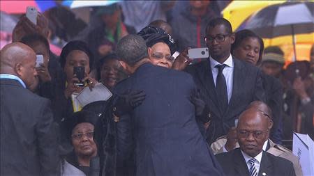 U.S. President Obama embraces Graca Machel during Mandela's national memorial service in Johannesburg