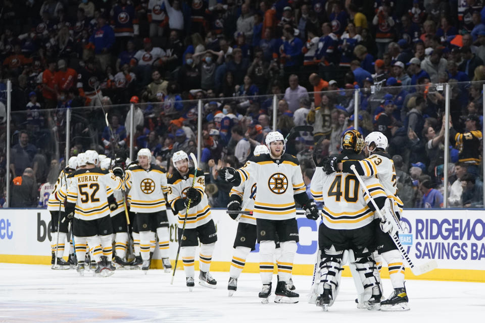 Boston Bruins goaltender Tuukka Rask (40) celebrates with Charlie McAvoy (73) and other teammates after Game 3 during an NHL hockey second-round playoff series against the New York Islanders Thursday, June 3, 2021, in Uniondale, N.Y. The Bruins won 2-1. (AP Photo/Frank Franklin II)