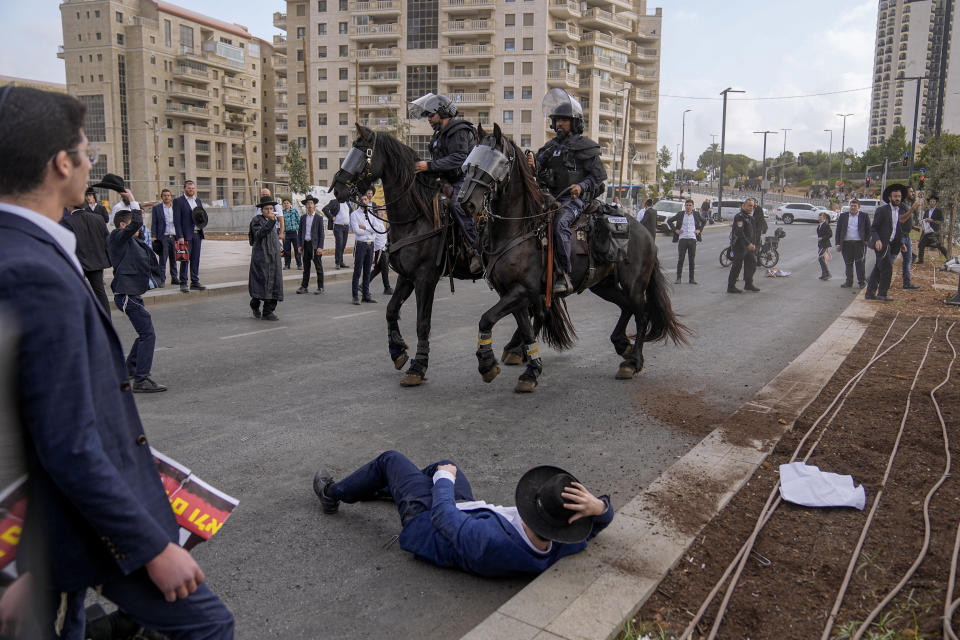 Israeli police officers disperse ultra-Orthodox Jewish men and boys blocking a road during a protest against the country's military draft, in Jerusalem, Wednesday, Sept.13, 2023. (AP Photo/Ohad Zwigenberg)