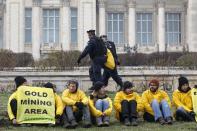 Greenpeace activists protest in the yard of Romania's Parliament, against a Canadian company's plan to set up Europe's biggest open-cast gold mine in Romania, in Bucharest December 9, 2013. A special Romanian parliament commission overwhelmingly rejected a draft bill that would have allowed Canada's Gabriel Resources to set up Europe's biggest open-cast gold mine in the small Carpathian town of Rosia Montana last month. However, parliament plans to revise a mining law that could open way for the project. REUTERS/Bogdan Cristel (ROMANIA - Tags: ENVIRONMENT SOCIETY CIVIL UNREST BUSINESS)