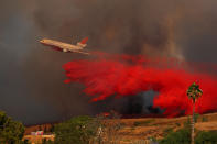 <p>A DC-10 aircraft drops fire retardant on a wind driven wildfire in Orange, Calif., Oct. 9, 2017. (Photo: Mike Blake/Reuters) </p>