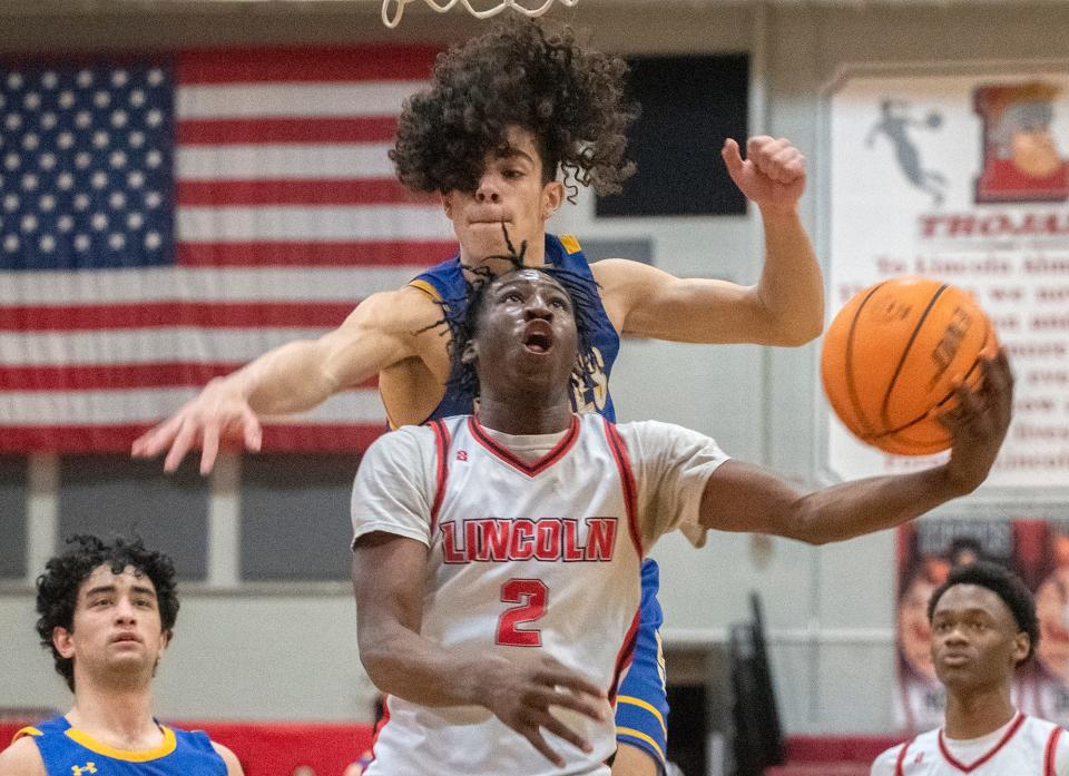 Lincoln's Donez Lindsey, bottom, goes to the hoop against Serra's Ryan Pettis during an opening round game of the CIF Boys DIv. 1 State Basketball championship tournament at Lincoln in Stockton on Feb. 27, 2024.