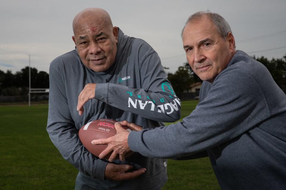 Former Moody halfback Raymond Huff, 68, of Corpus Christi, and former quarterback Abbey Cardenas, 67, of Dallas, pose for a portrait on the school's practice field on Wednesday, Nov. 22, 2023, in Corpus Christi, Texas.