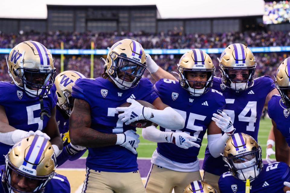 The Washington Huskies celebrate after a fourth down defensive stop against the Utah Utes during the second half at Alaska Airlines Field at Husky Stadium Nov. 11 in Seattle.