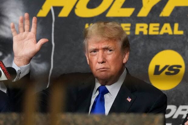 Former President Donald Trump waves to cheering fans as he prepares to provide commentary for a boxing event headlined by former heavyweight champ Evander Holyfield and former MMA star Vitor Belfort. (Rebecca Blackwell/The Associated Press - image credit)