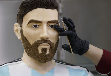 An employee of Altufyevo Confectionery finishes the preparation of a life-size chocolate sculpture of Argentine soccer player Lionel Messi to top a cake for the celebration of his upcoming birthday in Moscow, a host city for the World Cup, Russia June 23, 2018. REUTERS/Tatyana Makeyeva