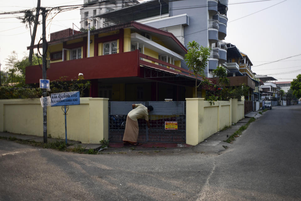 Neighbor and caretaker Belief locks the gate after watering the plants at the home of V.Baby, who currently lives with his wife at the Signature Aged Care which is just a few kilometers from here in Kochi, Kerala state, India, March 12, 2023. When his 82-year-old wife Vasanthi almost tripped while climbing down the stairs of their home in the heart of the city, the retired math professor made up his mind to move to an assisted living center. (AP Photo/ R S Iyer)