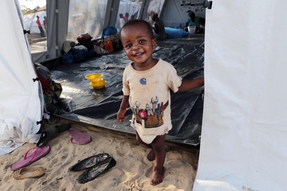 A baby smiles while in a compound set up for displaced people suspected to have cholera in Beira, Mozambique, Tuesday, March, 26, 2019. Relief operations pressed into remote areas of central Mozambique where an unknown number of people remain without aid more than 10 days after a cyclone ripped across the country, while trucks attempted to reach the hard-hit city of Beira on a badly damaged road. (AP Photo/Tsvangirayi Mukwazhi)