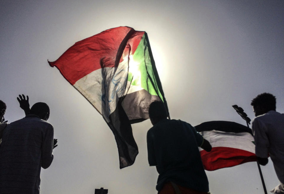 Sudanese demonstrators march with national flags as they gather during a rally demanding a civilian body to lead the transition to democracy, outside the army headquarters in the Sudanese capital Khartoum on Saturday, April 13, 2019. The military overthrew President Omar al-Bashir on Thursday after almost four months of protests calling for an end to his nearly 30-year rule. (AP Photo)