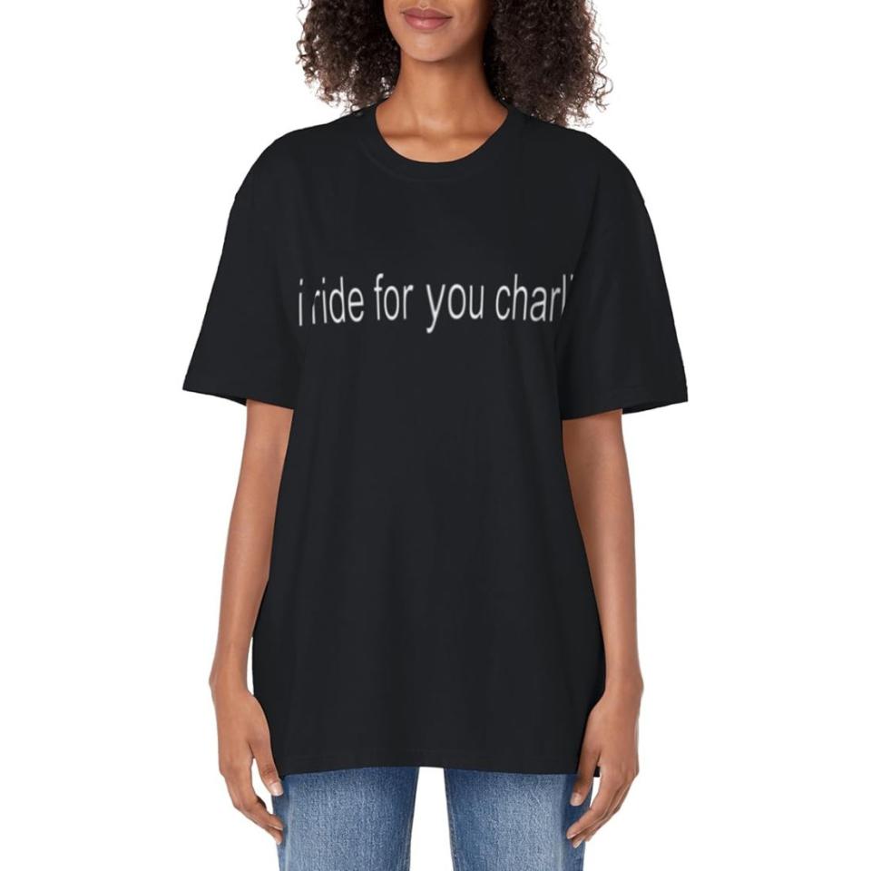 model wearing black and white "I ride for you Charlie" t-shirt with jeans