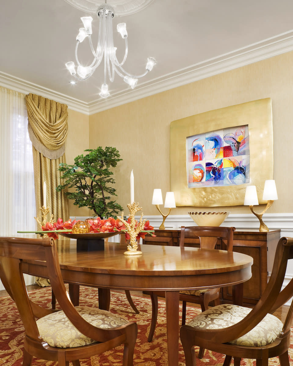 This publicity photo provided by Chrisicos Interiors LLC shows a silk tree from NESA of a bonsai, rear, in a traditional metallic gold toned elegant dining room in Newton, Mass. Improved manufacturing methods and materials are giving artificial plants and silk flowers a fresh reputation. (AP Photo/Chrisicos Interiors LLC, John Horner Photography)