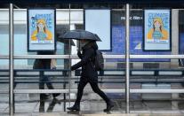 A woman walks past banners, ahead of a youth climate protest in Bristol