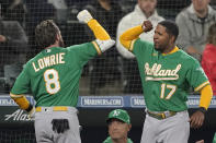 Oakland Athletics' Jed Lowrie (8) is greeted at the dugout by Elvis Andrus (17), after Lowrie hit a two-run home run during the fifth inning of a baseball game against the Seattle Mariners, Tuesday, May 24, 2022, in Seattle. Andrus hit a solo home run during the sixth inning. (AP Photo/Ted S. Warren)