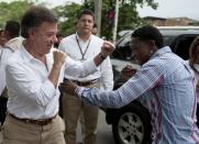 El presidente colombiano, Juan Manuel Santos(I) posa durante su campaña electoral por la reelección con el excampeón de boxeo peso gallo Jhonatan 'Momo' Romero, en el Distrito de Aguablanca, en Cali, Colombia, el 3 de abril de 2014. (AFP | Luis Robayo)