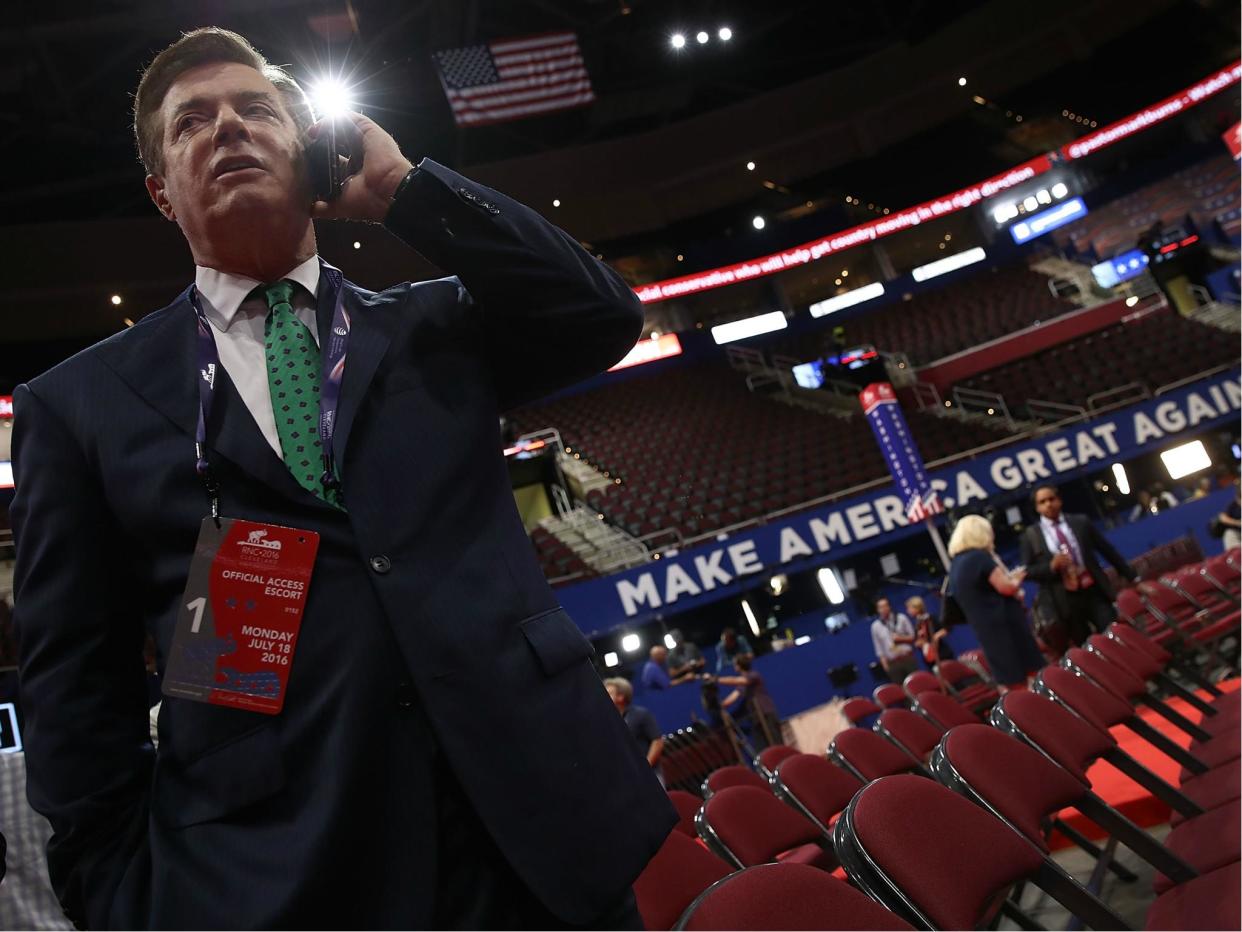 Paul Manafort, former campaign manager for President Donald Trump, speaks on the phone while touring the floor of the Republican National Convention 17 July 2016 in Cleveland, Ohio: Win McNamee/Getty Images