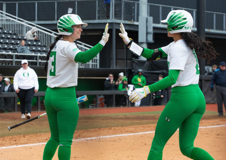 Oregon’s Ariel Carlson, left, congratulates Alyssa Daniell after her sacrifice bunt scored the first run of the game against Maryland during the Jane Sanders Classic at Jane Sanders Stadium Saturday, March 2, 2024.