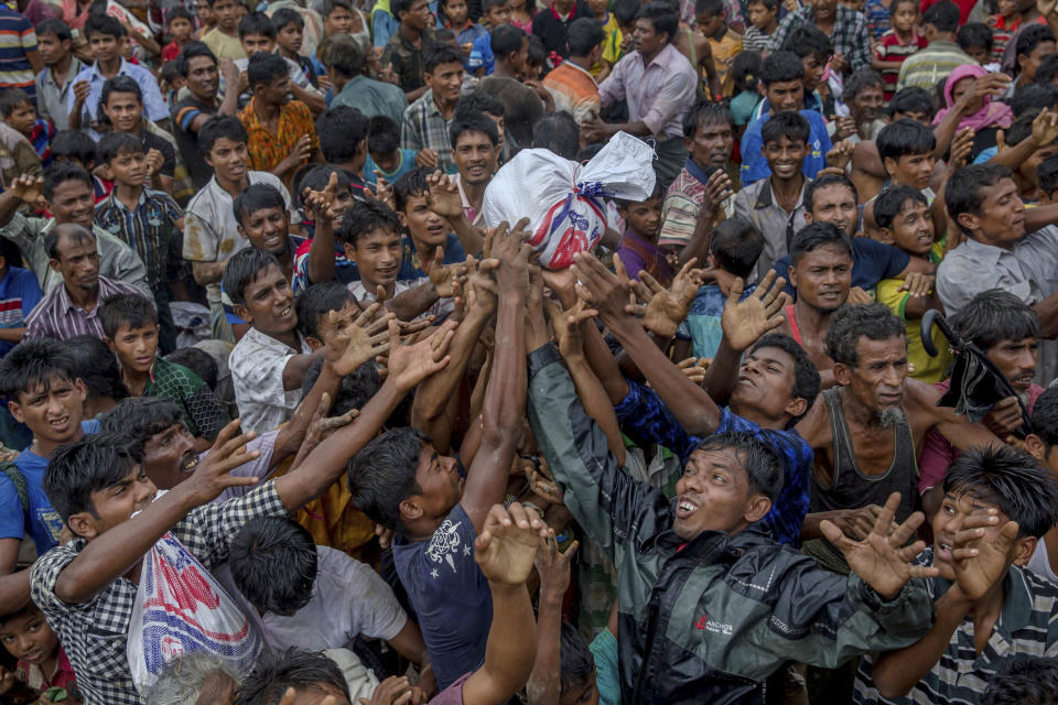 <p>Rohingya Muslims, who crossed over from Myanmar into Bangladesh, stretch their arms out to collect food items distributed by aid agencies near Balukhali refugee camp, Bangladesh, Monday, Sept. 18, 2017. (Photo: Dar Yasin/AP) </p>