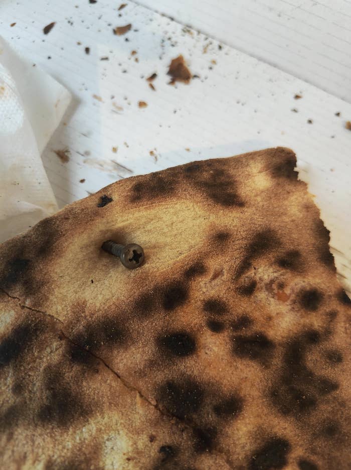 Burnt pizza with a screw on top