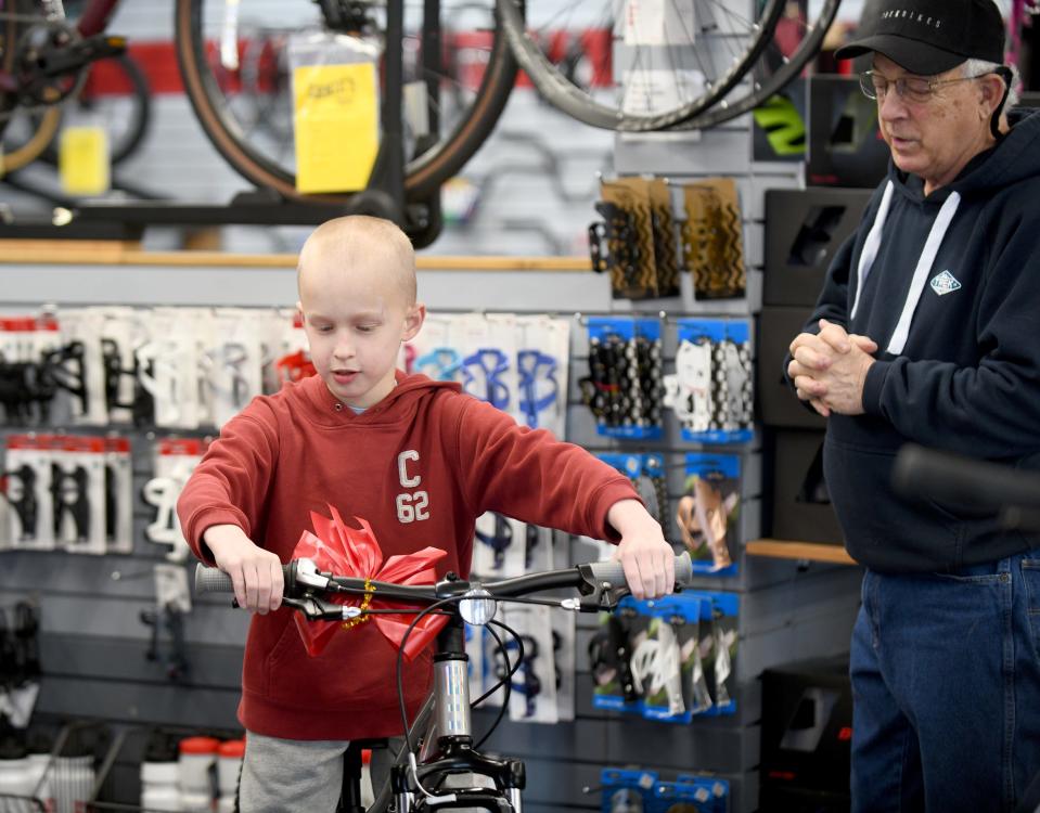 Jordan Owens, 9, who was injured in a Labor Day bicycle accident, get pointers on his new bike from Dave Viola at Ernie's Bike Shop in North Canton. An anonymous donor bought the bike for him after reading about him in The Repository.