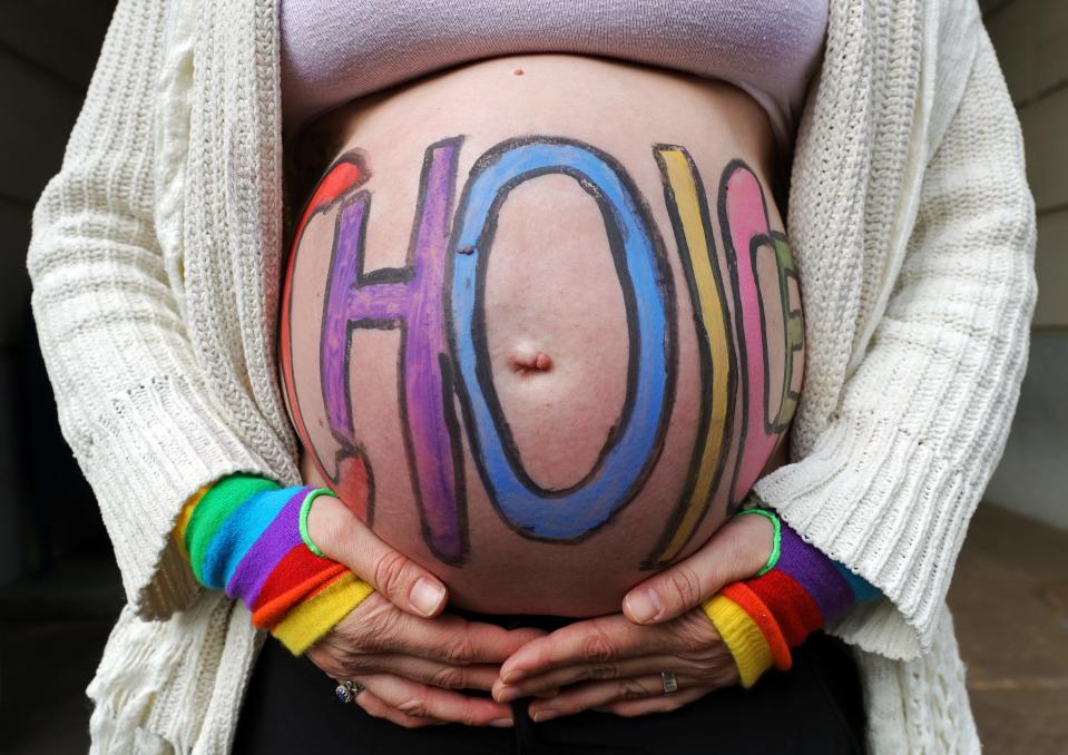 Beth Vild, chief operating officer of Big Love Akron, celebrates her choice to have a family during the Bans Off Akron rally for reproductive rights Sunday outside Akron City Hall.