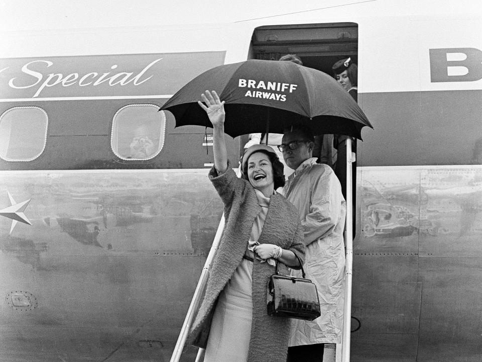 Lady Bird Johnson, wife of President Lyndon Johnson, greets well wishers upon landing aboard a Braniff International Airways Lockheed Electra dubbed "The Lady Bird Special"