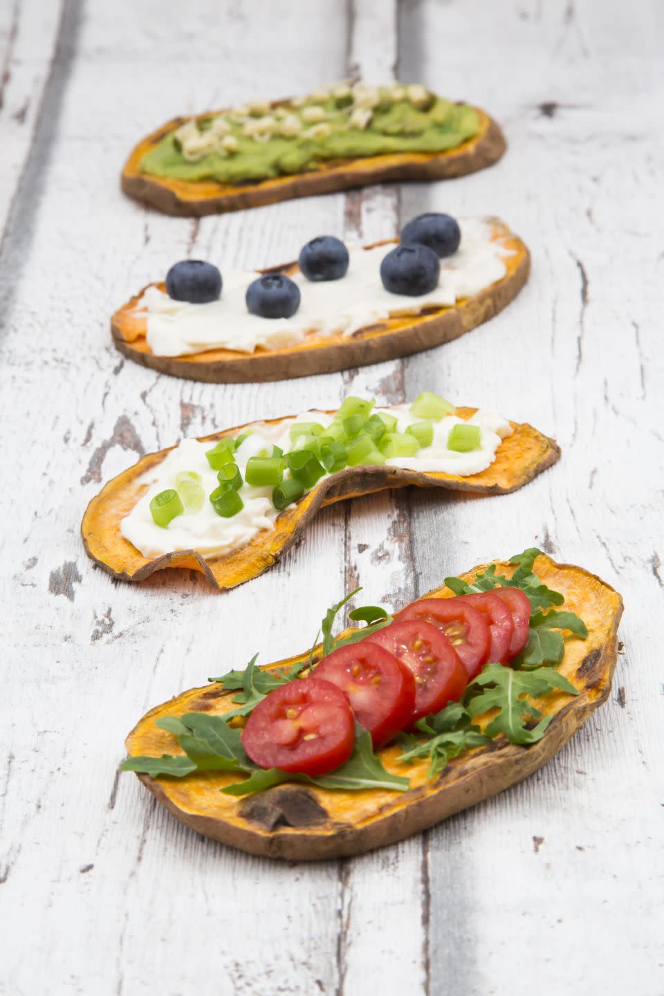 süßkartoffel toast mit avocado creme und sprossen, friscjkäse und frühlingszwiebeln, frischkäse und heidelbeeren, ruccola und tomaten