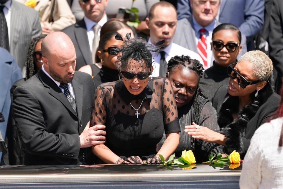 Friends and family console Kalabrya Haskins, the widow of former Ohio State quarterback Dwayne Haskins, after a memorial service on Friday.